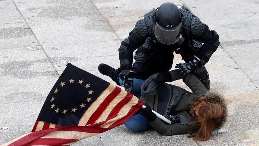 Un policía detiene a uno de los manifestantes ante el Capitolio.