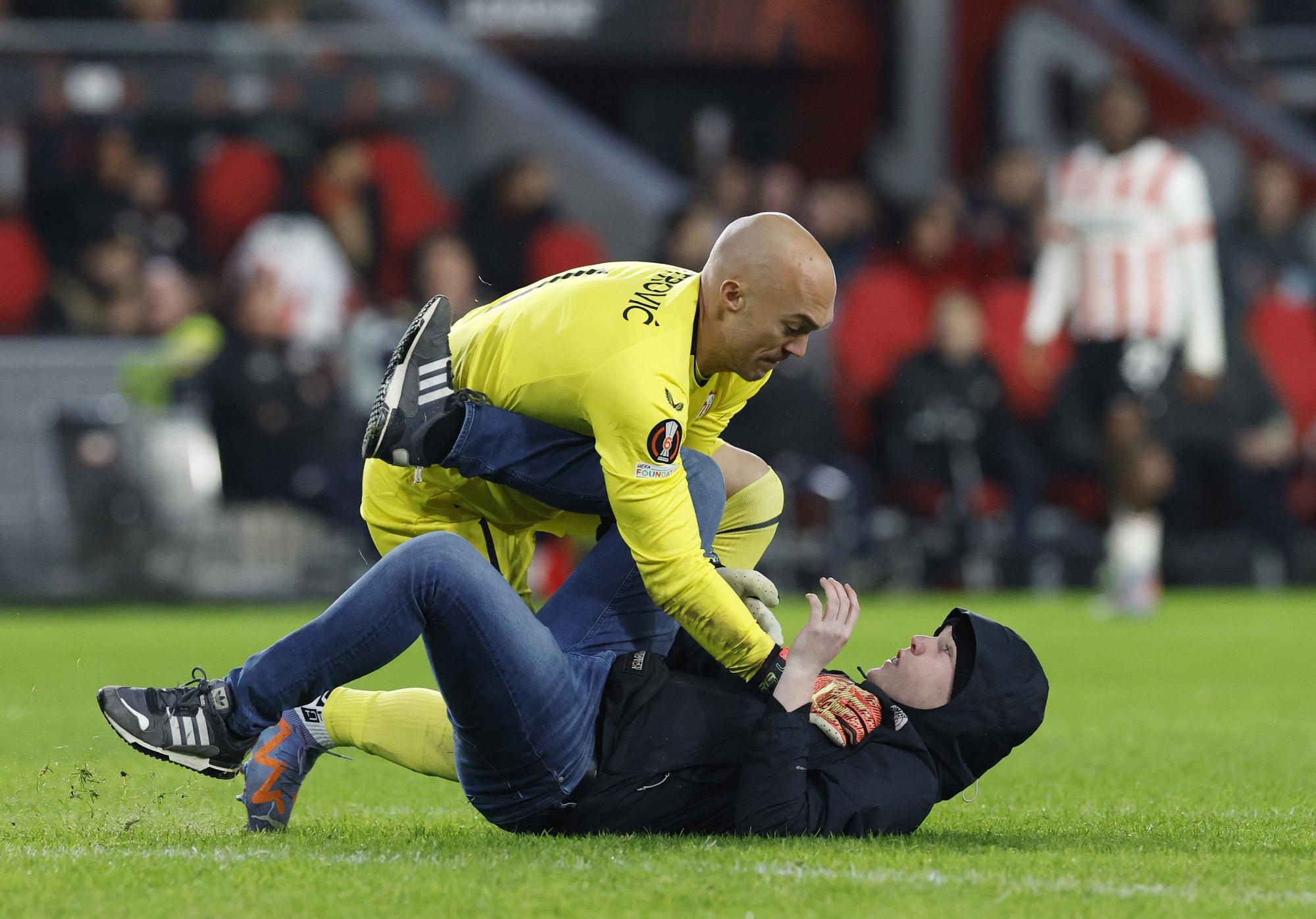 Un espectador salta al campo durante el PSV-Sevilla e intenta agredir a Dmitrovic