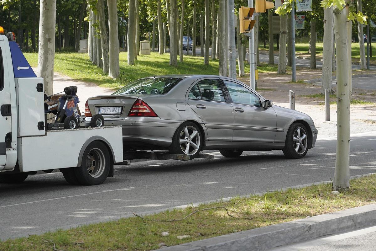Una grua municipal retirant un vehicle de la via pública.