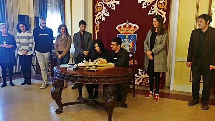 Tati Moyano y Carlos Jiménez firman ayer en el libro de honor durante el acto en el Ayuntamiento de Ferrol.