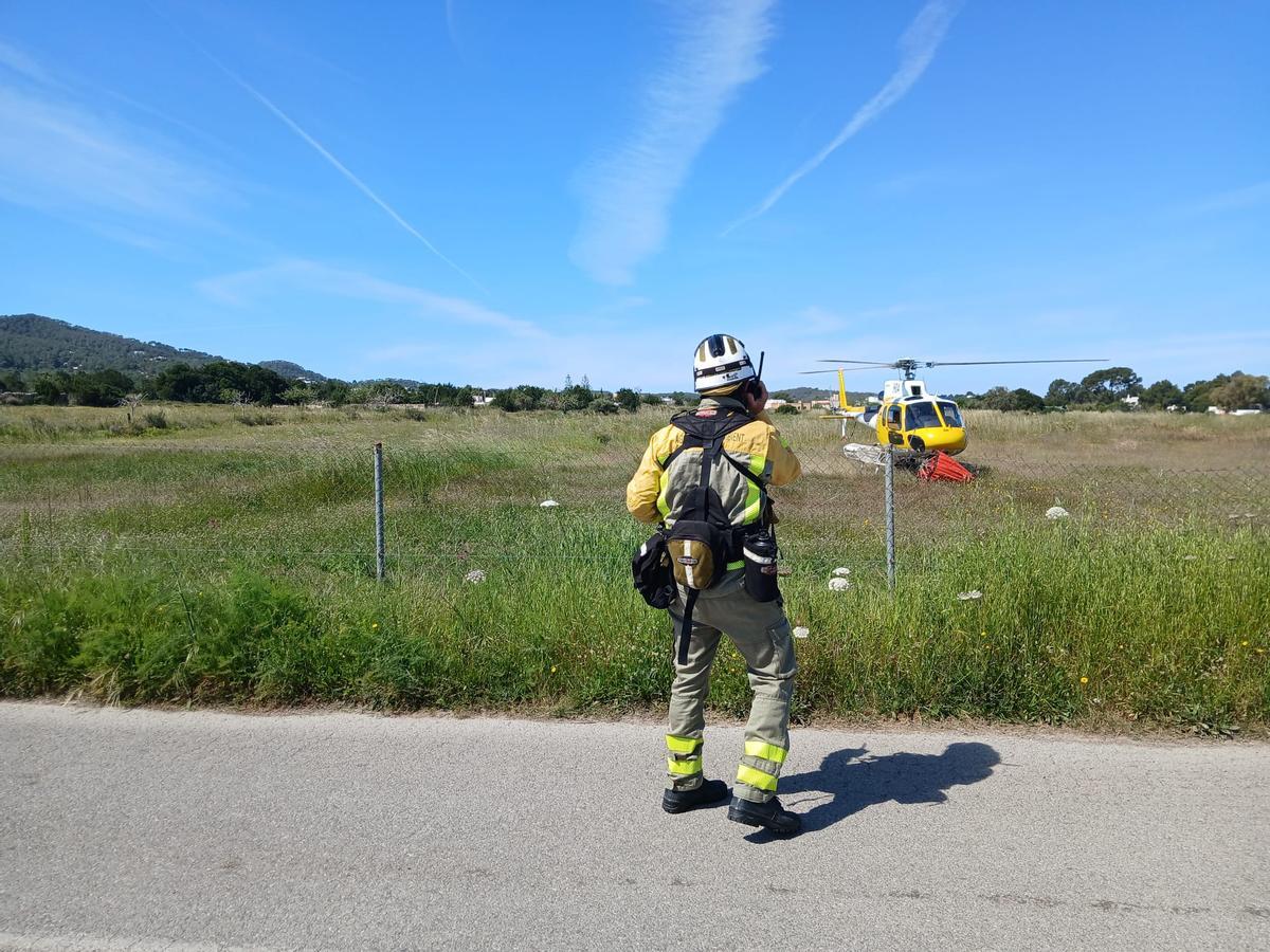 Un bombero junto al helicóptero del Ibanat en la zona afectada