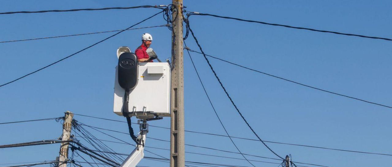 Un electricista de una empresa cambia las farolas convencionales de Cambados por otras led. | // I.ABELLA