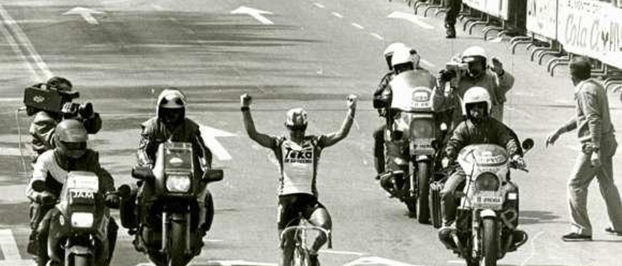 Arriba, Carlos Hernández levanta los brazos celebrando su victoria en la calle Uría en 1987. Sobre estas líneas, la entrada del pelotón.