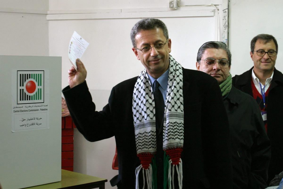 epa000343310 epa000343308 Mustafa Barghouti, presidential candidate, holds up his ballot paper as he votes in the Palestinian presidential election at the polling station at Friends School in the West Bank town of Ramallah on Sunday 09 January 2005. EFE/epa/ATEF SAFADI / ELECCIONES PRESIDENCIALES EN PALESTINA