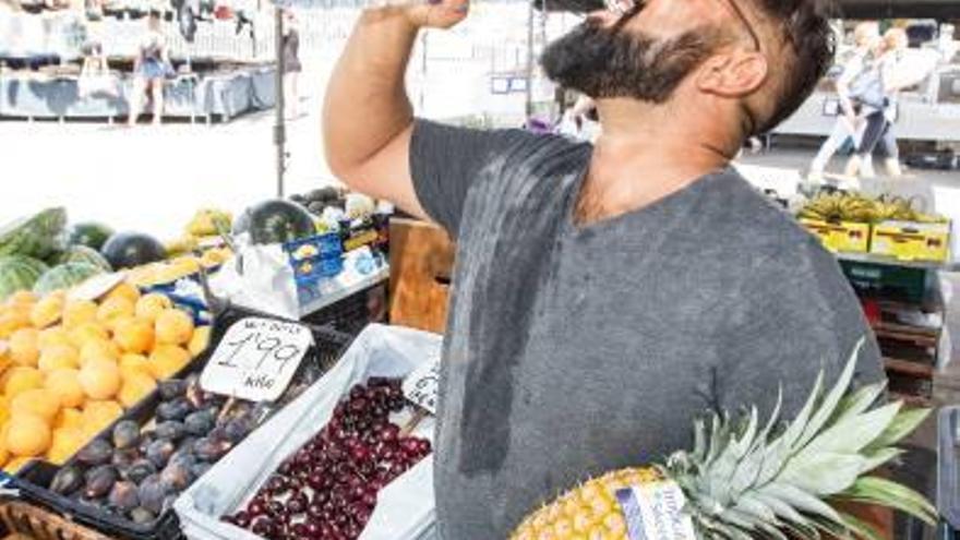 El frutero Pepe Moreno bebe agua en su puesto ayer en el mercadillo de Teulada.