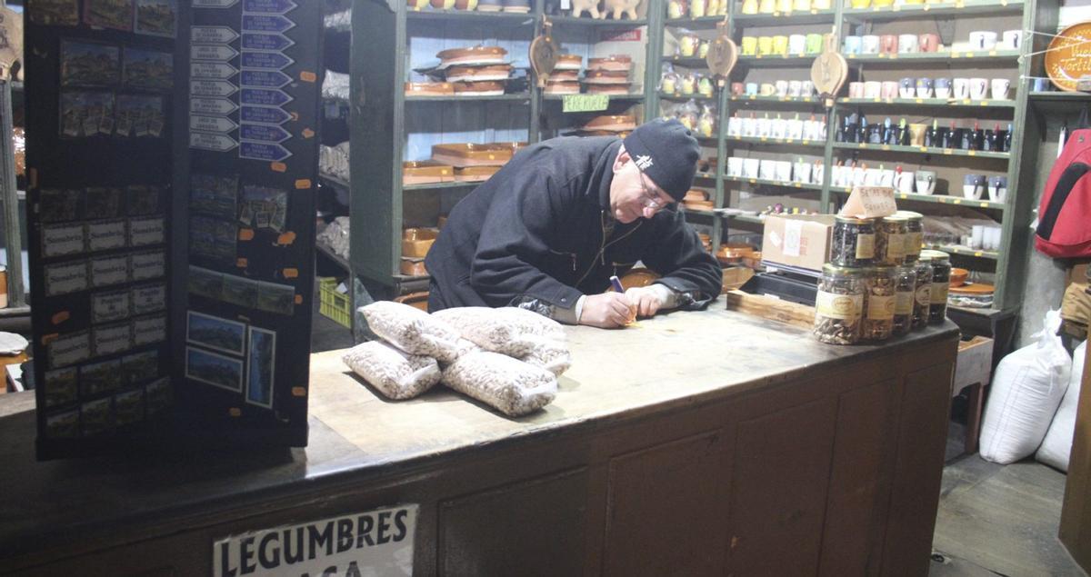 Vicente Morán Vasallo haciendo las cuentas a mano en el antiquísimo mostrador de su tienda.  | ARACELI SAAVEDRA