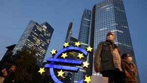 (FILES) In this file photo taken on October 21  2020 people wearing face masks walk in front of the euro sign at the former ECB headquarters in the city center of Frankfurt am Main  western Germany  - The European Central Bank is expected Thursday to unleash more stimulus to help shore up a eurozone economy devastated by the coronavirus pandemic  analysts said  in a move eagerly awaited by financial markets   The Frankfurt institution already has a 1 35-trillion-euro ( 1 6-trillion) emergency bond-buying programme in place  but ECB chief Christine Lagarde all but promised in October that extra support was on the way  (Photo by Yann Schreiber   AFP)