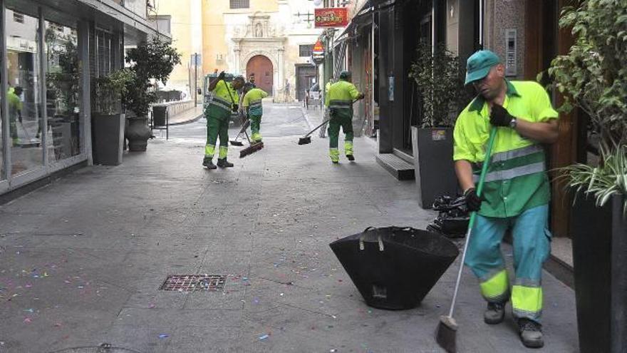 Operarios de la empresa Urbaser limpiando una calle del centro de la ciudad tras la Nit de la Roà.