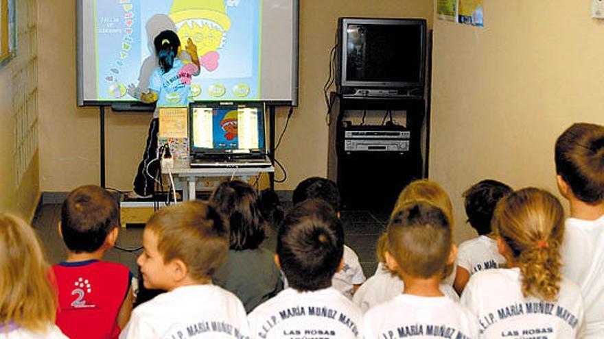 Los niños del Colegio María Muñoz Mayor del barrio de Las Rosas utilizando una de las pizarras digitales.