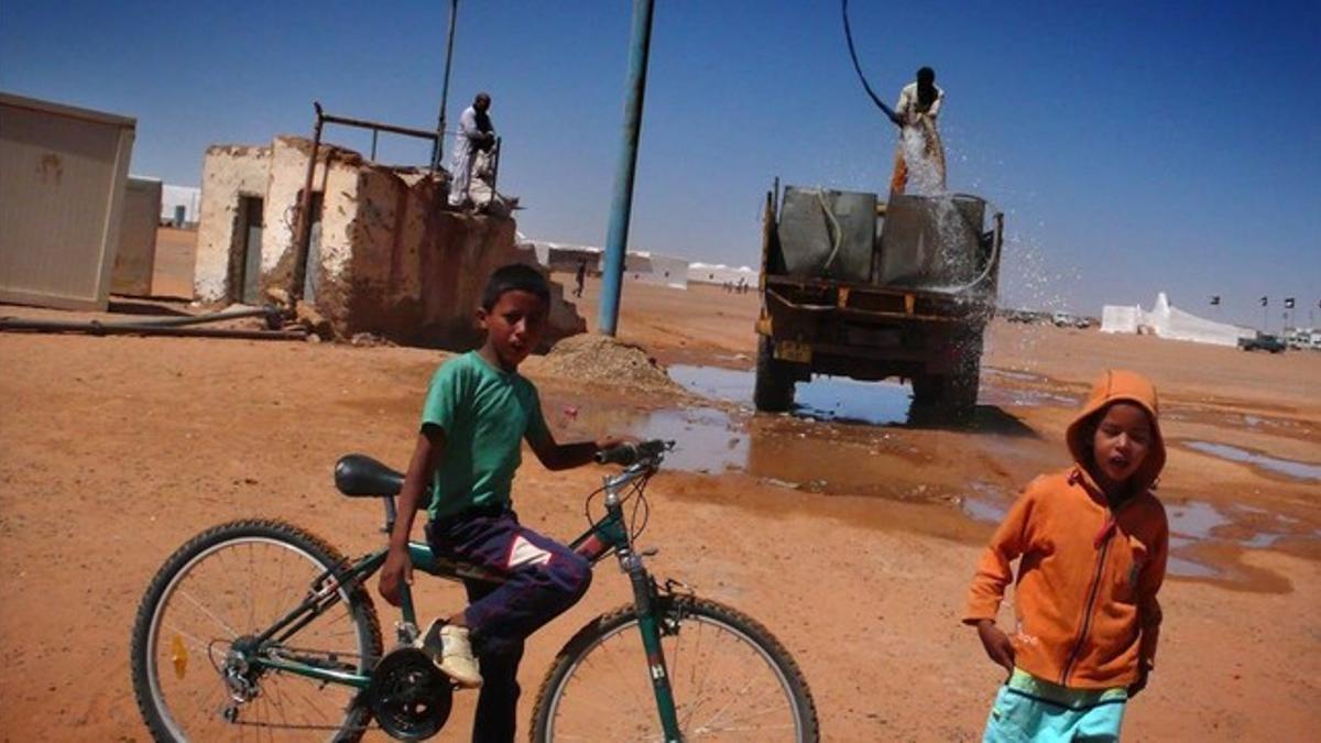 Jóvenes saharauis junto a una cisterna que reparte agua a precario en el campamento Dajla (Tinduf), en una imagen de archivo.