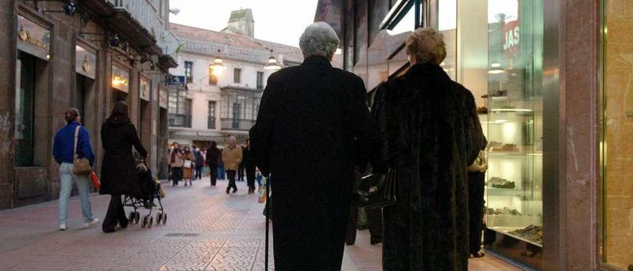 Dos personas mayores caminan por la calle Oliva. // Gustavo Santos