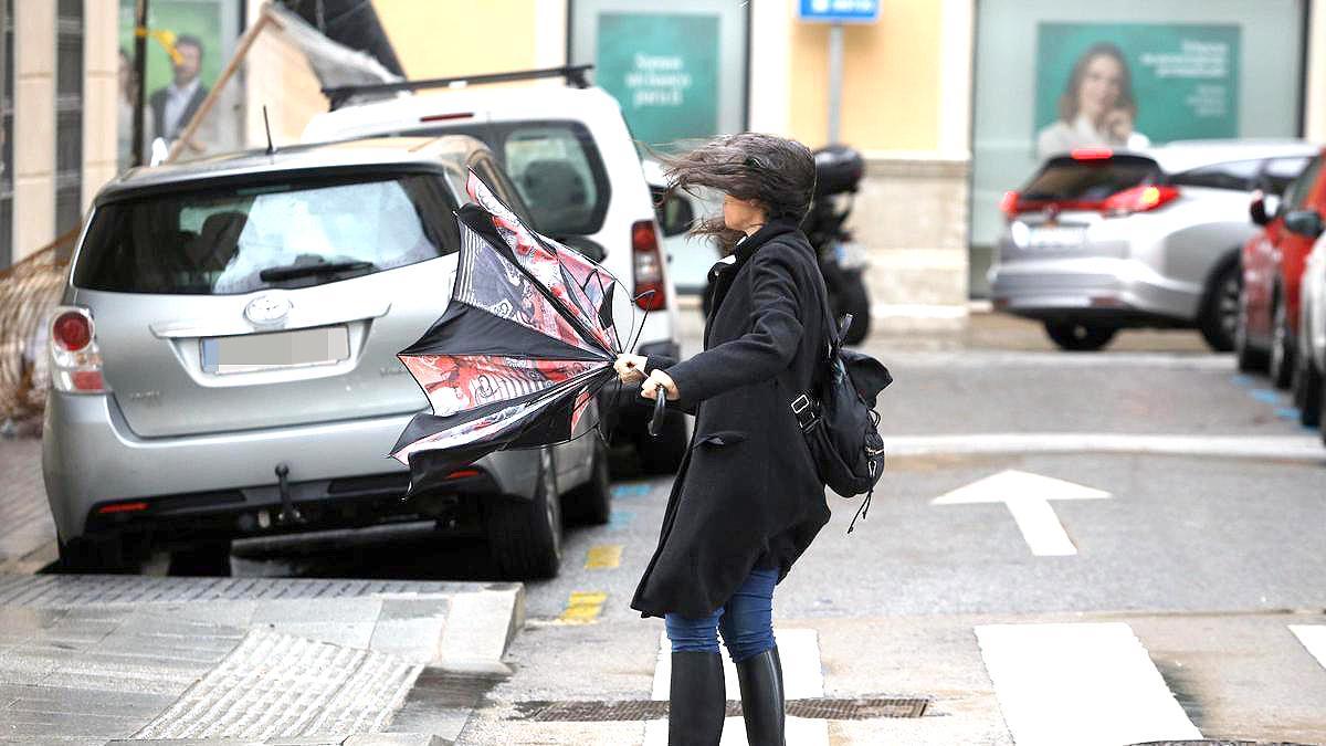 Transeúnte paseando por el centro de Málaga en una jornada donde la borrasca Oriana deja fuertes vientos.