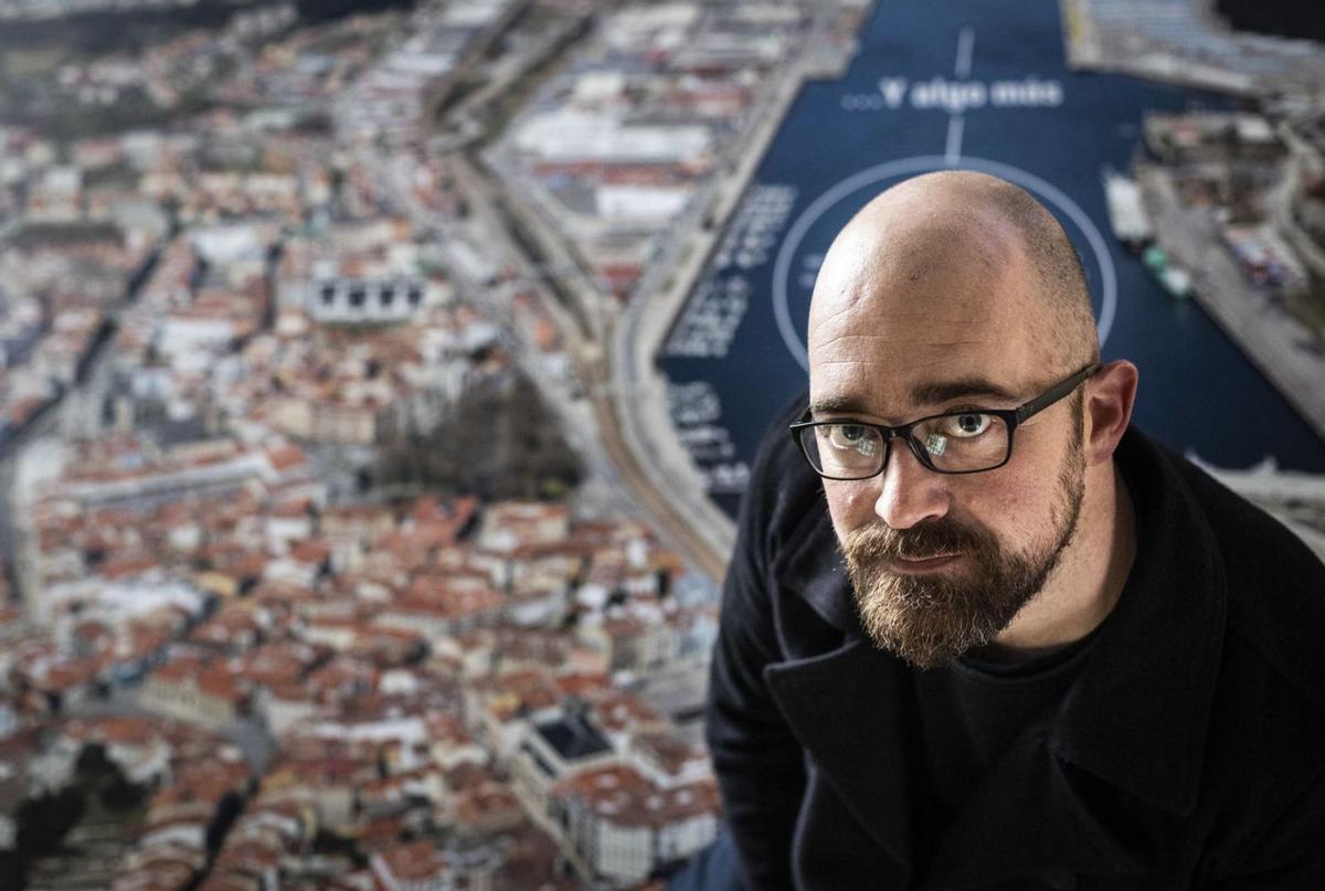 Nicolás Alonso, en el Espacio Portus,  ante una foto aérea de Avilés.