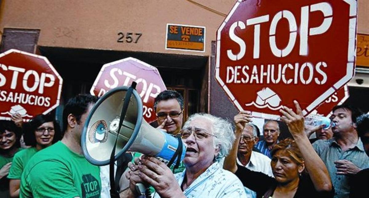 Alleujada 8 María Teresa Alsina celebra megàfon en mà i amb el seu fill la paralització del desnonament, ahir.