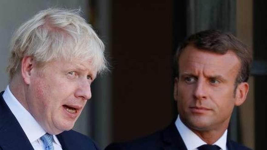 Boris Johnson (izda.) con Emmanuel Macron, ayer. // Reuters