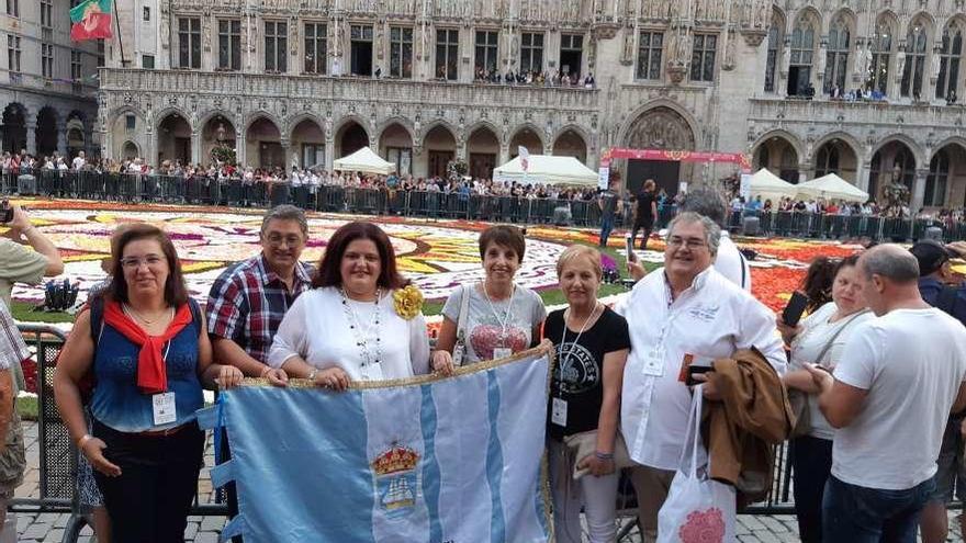 Los alfombristas de Bueu en la Grand Place de Bruselas con la bandera del Concello. // FdV