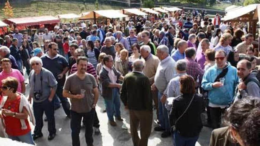 Arriba, ambiente en la Festa del viño de Pesoz; a la izquierda, una artesana del vidrio en la feria de Bres.