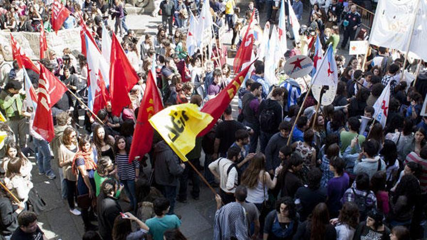 Centenares de manifestantes con pancartas en contra de la subida de la matrícula, ayer en la Plaza de O Toural de Santiago.  // O. Corral