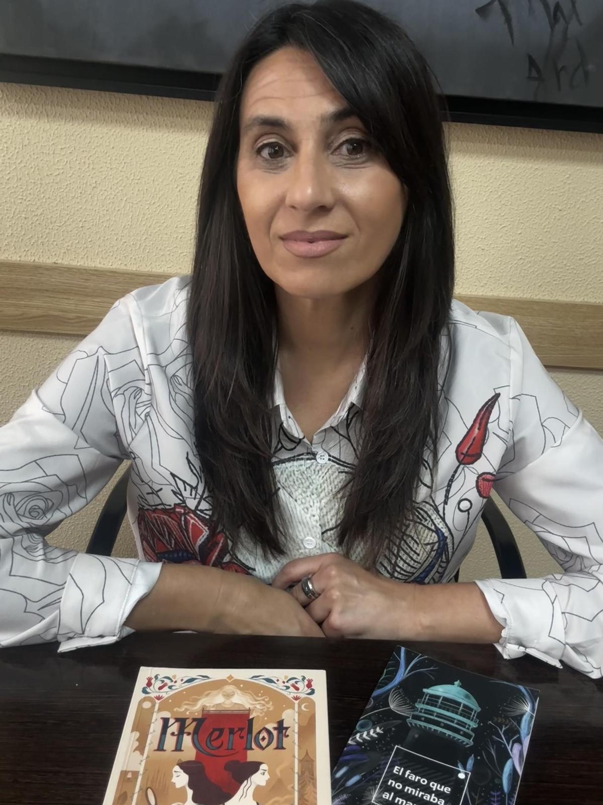 Natalia Menéndez posa con sus novelas "Merlot" y "El faro que no miraba al mar"