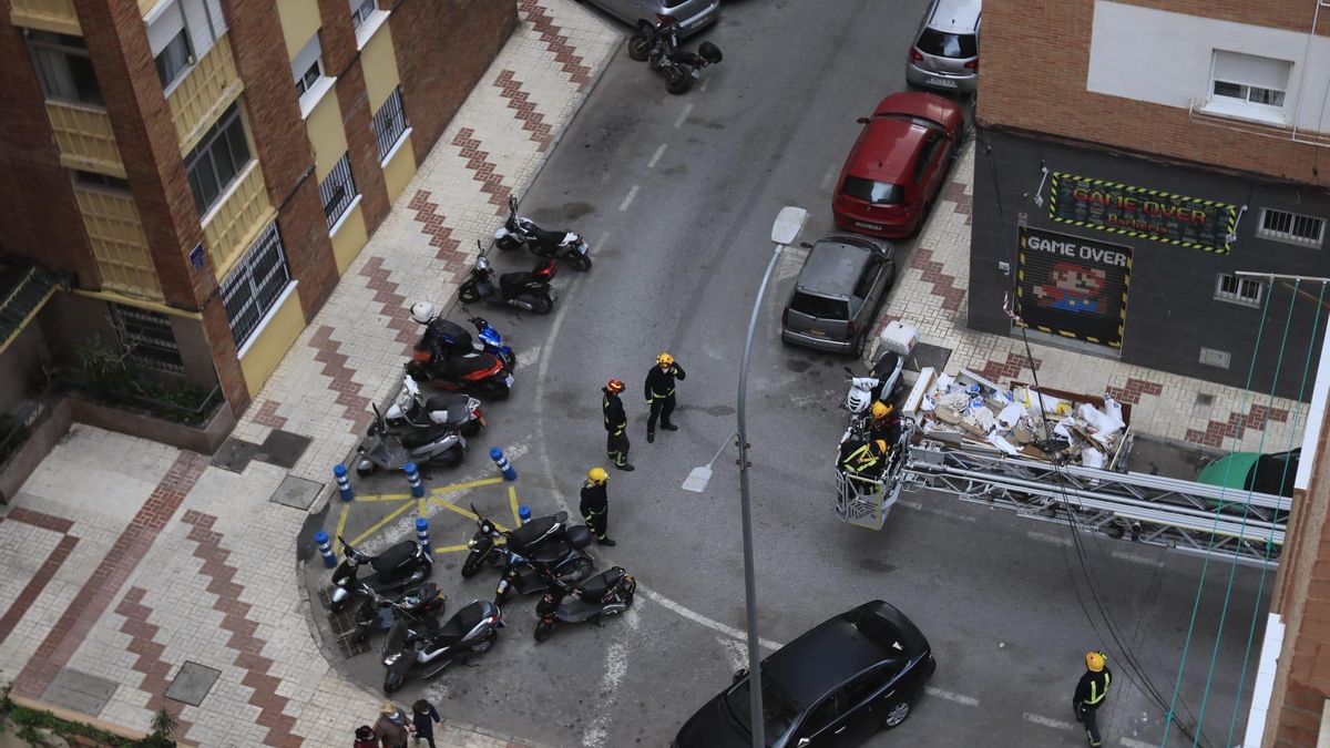 Efectivos de Bomberos retiran unos cables que se han descolgado por el viento en la calle Barca de Miraflores de los Ángeles.