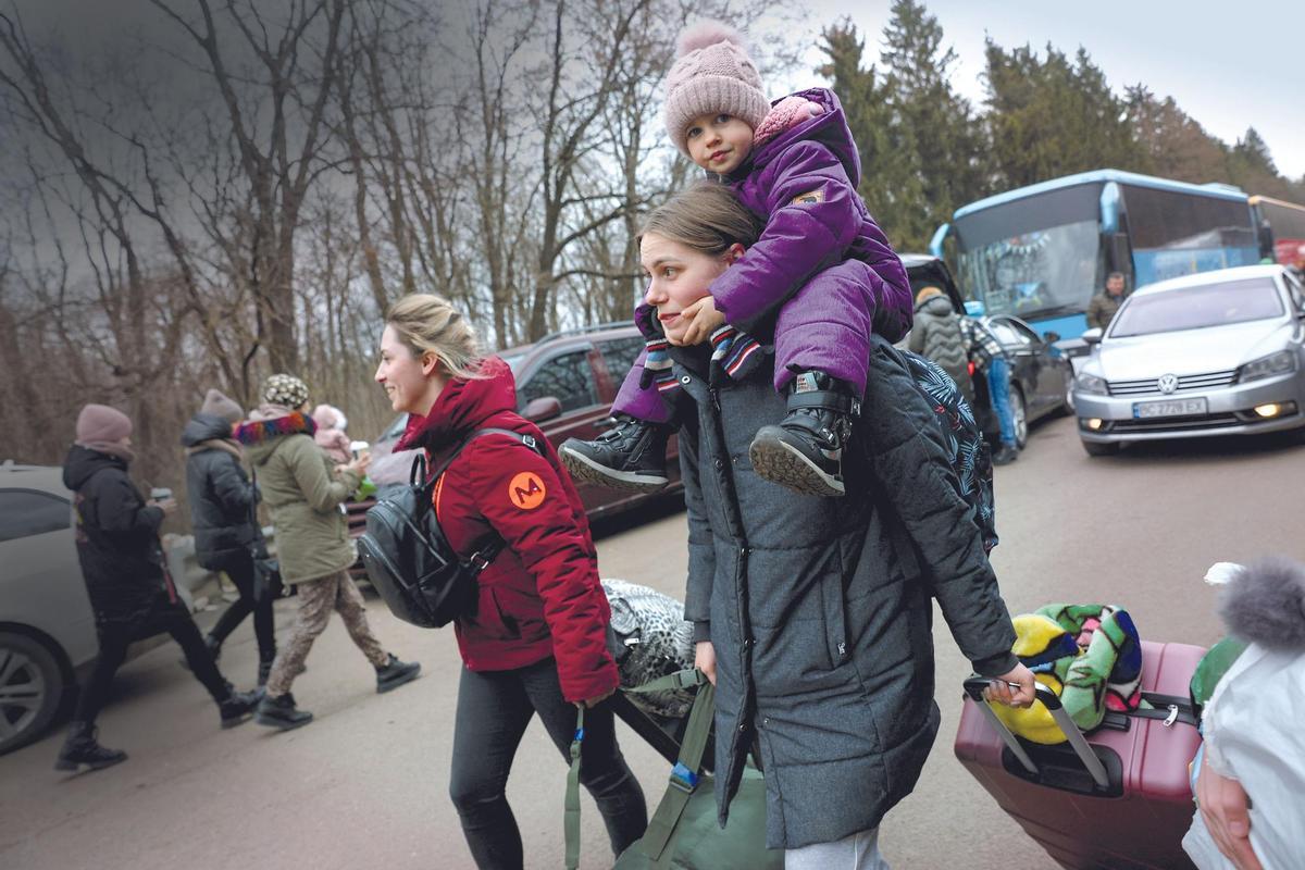 Mujeres y niños ucranianos cruzan la frontera con Polonia.