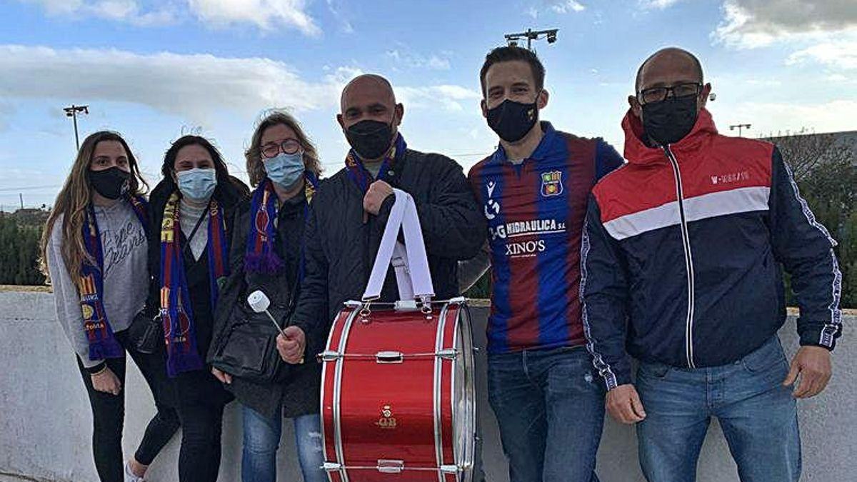 Hinchas del Poblense posan en la grada con un bombo.
