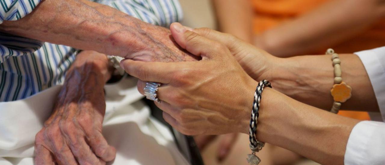 Una mujer sostiene la mano de una persona anciana. | Europa Press