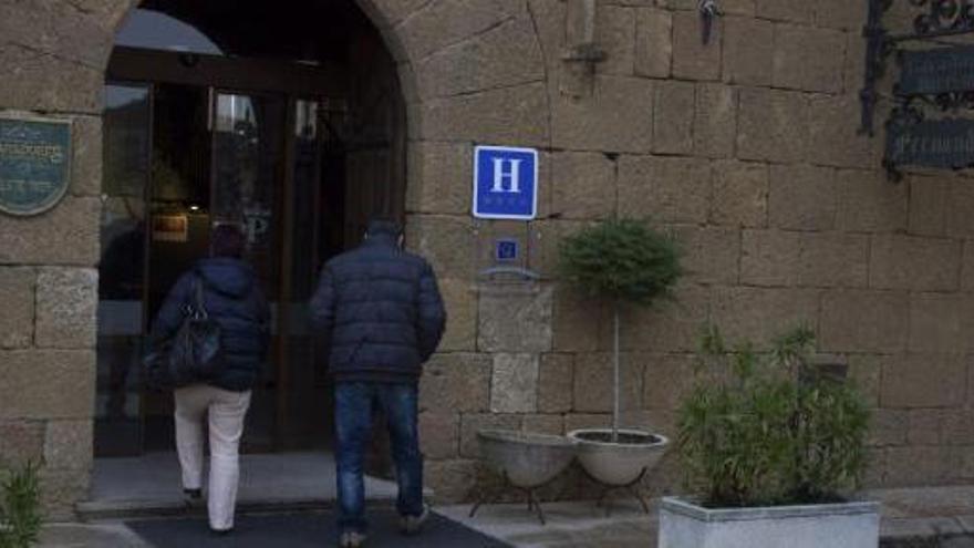 Dos personas entran, ayer, en el Parador Fernando II de Benavente.