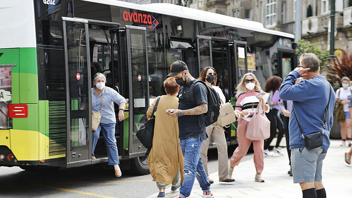 Pasajeros en una parada de Vitrasa, en Urzáiz. |  // RICARDO GROBAS