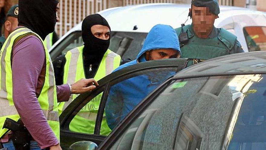 Els agents fan entrar un dels detinguts en un vehicle