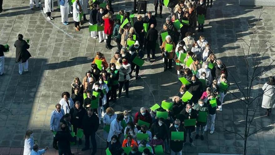 Un grupo de trabajadores del CHUO e integrantes de la AECC formaron un lazo solidario.  // F. CASANOVA