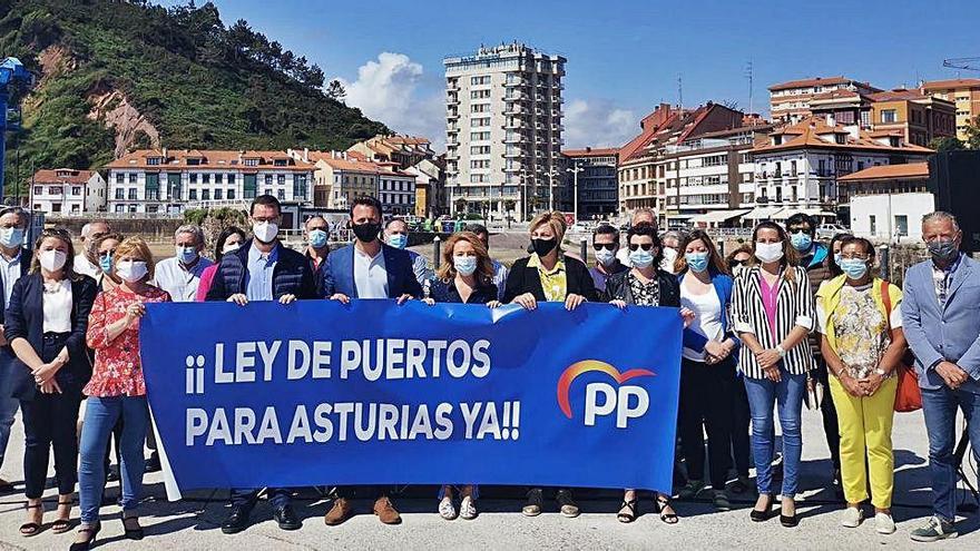 Teresa Mallada, en el centro, sosteniendo la pancarta, arropada por diputados y presidentes y portavoces de las juntas locales del PP de los concejos costeros, ayer, en el muelle de Candás.