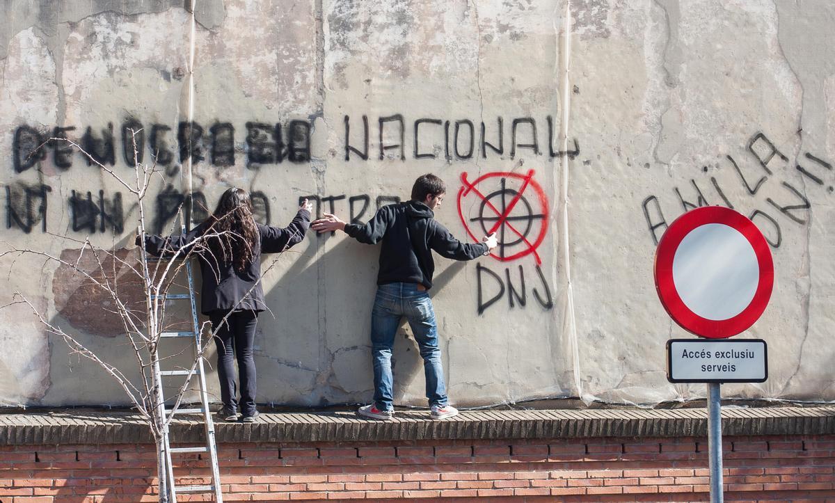 Jóvenes activistas tachan pintadas fascistas en Barcelona en 2014.