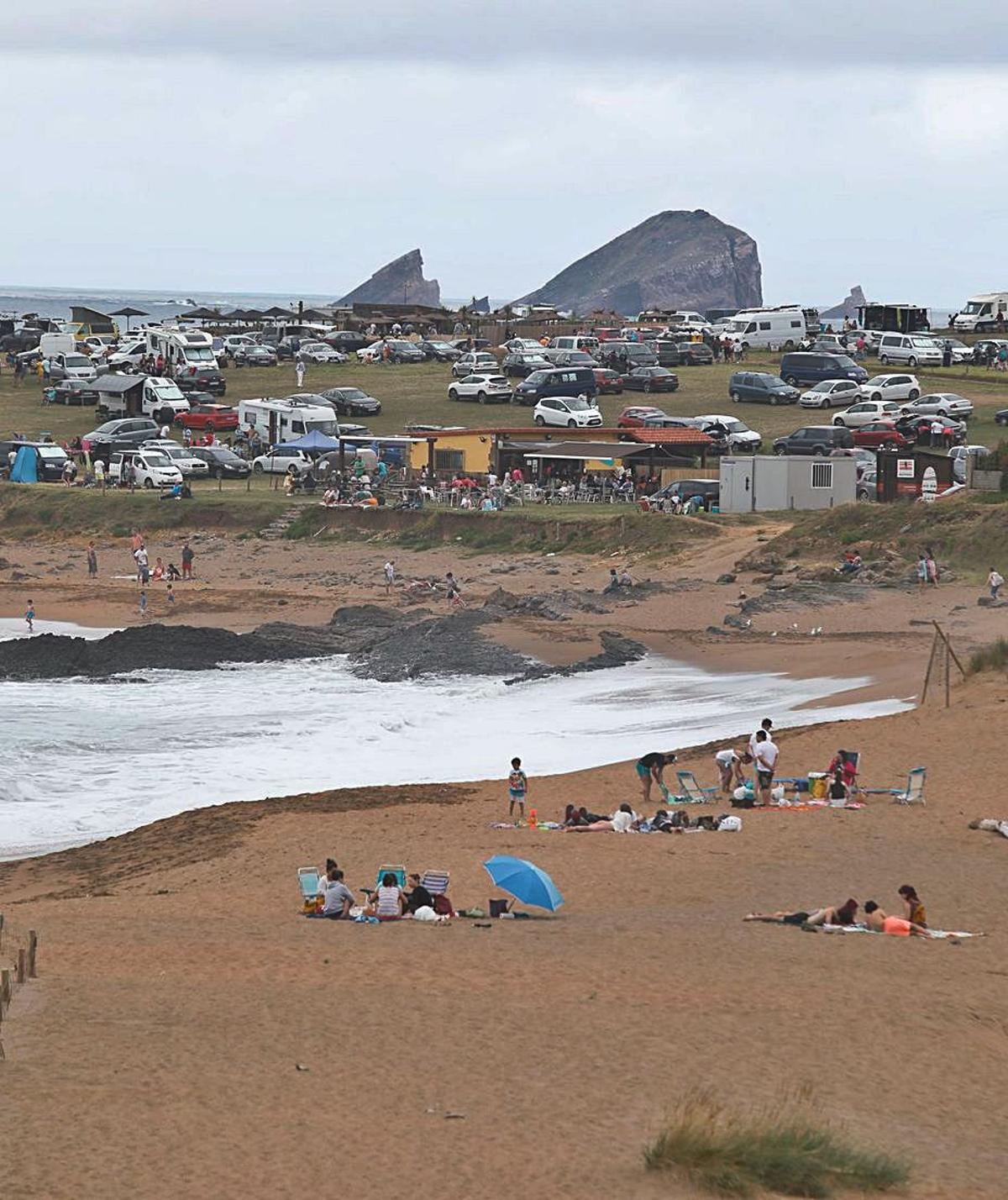 El aparcamiento de furgonetas de la playa de Verdicio, el verano pasado, con el Cabo Peñas al fondo. | Mara Villamuza