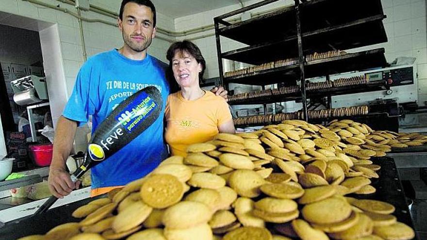 Walter Bouzán con Toñi Junco, de la fábrica La Abuela, rodeados de las galletas que cada día desayuna el campeón, abajo en plena fanea. / miki lópez