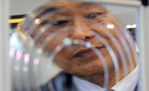 Un home mira a través d’una lent plàstica Fresnel durant una demostració a la Nano Tech 2011, la fira de nanotecnologia més gran del món, que va obrir les portes a Tòquio (Japó).