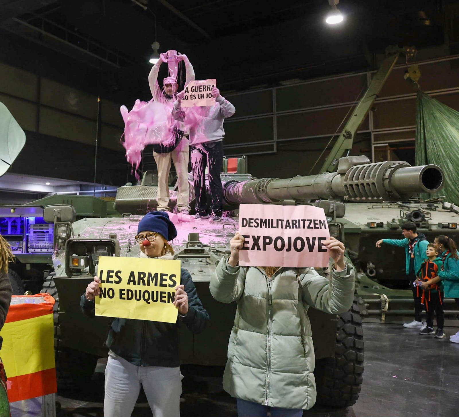Unos pacifistas rocían pintura rosa sobre una tanqueta en Expojove: "Las armas no educan"