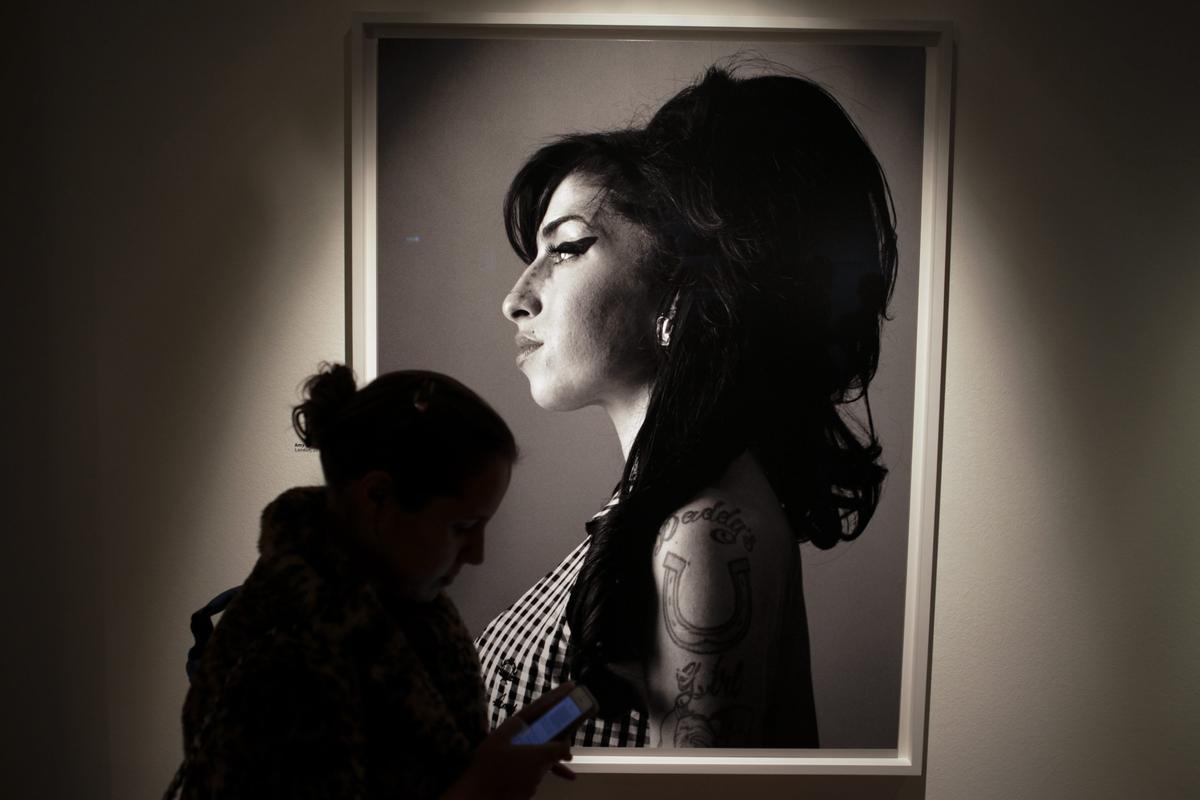 Una exposición de fotos con un retrato de Amy Winehouse.