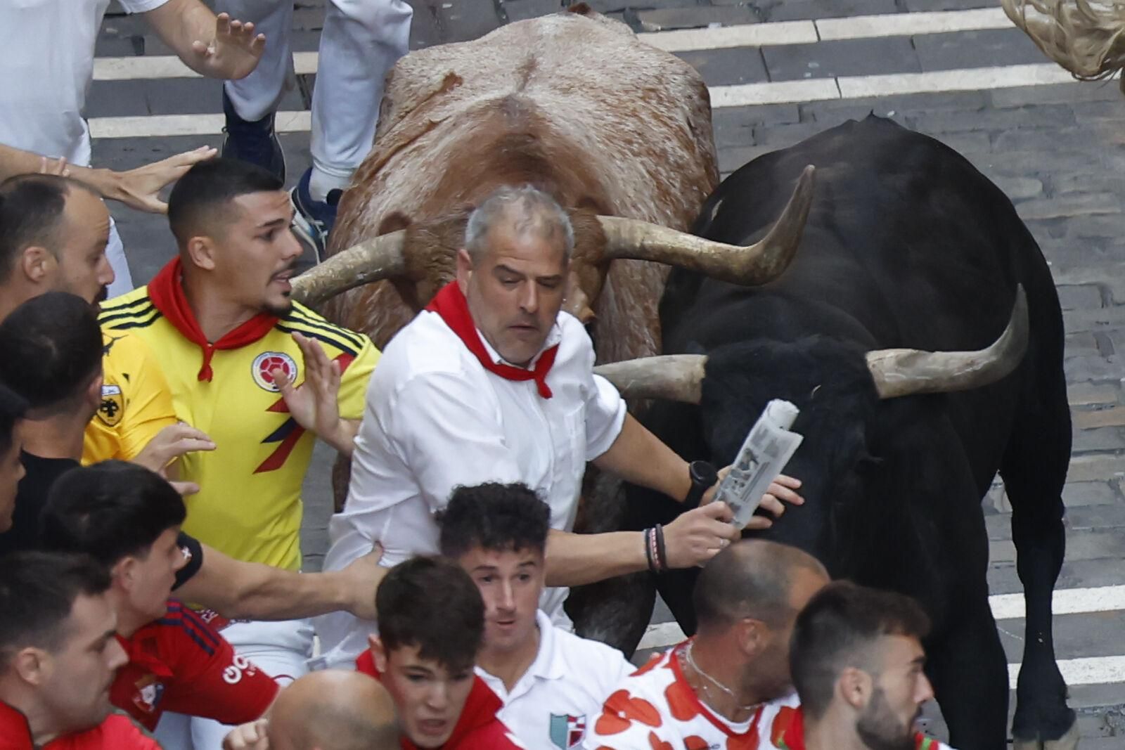 PAMPLONA, 14/07/2025.- Los mozos son perseguidos por toros de la ganadería sevillana de Miura durante el octavo y último encierro de los Sanfermines este lunes. EFE/ Jesús Diges