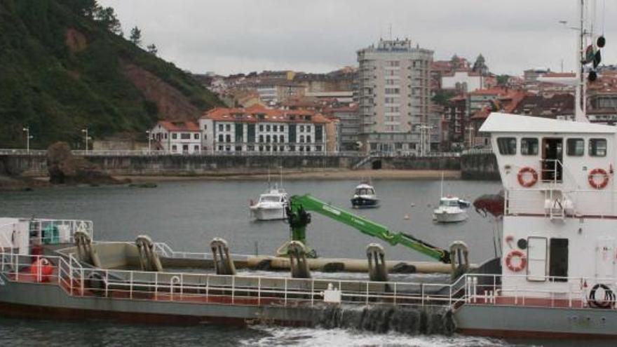 Una draga operando en la dársena exterior del puerto de Candás.