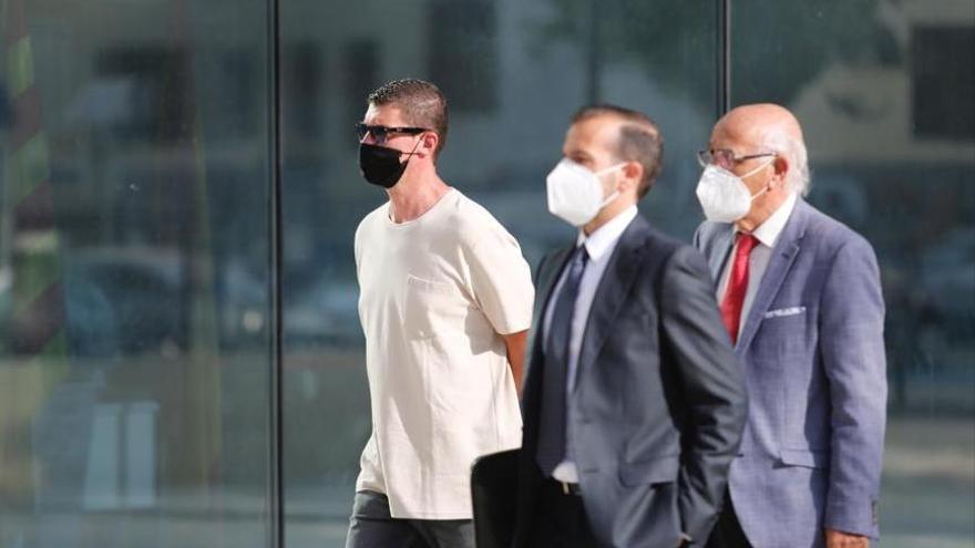 Uno de los acusados del robo al Grupo Empresas Matutes, con camiseta blanca, junto a sus abogados,  a su llegada a los juzgados de Ibiza