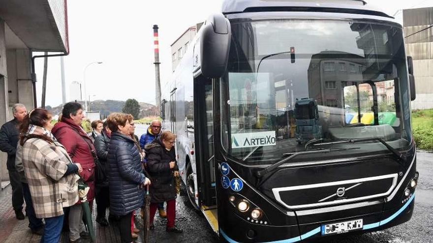 Vecinos suben al autobús de la línea circular entre Meicende y Arteixo.