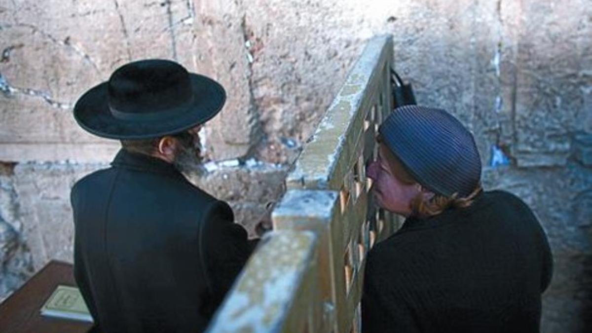 Segregación 8 Un ultraortodoxo y una mujer rezan separados por una celosía frente al muro..
