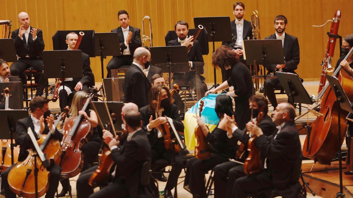 Los rusos Marina Gurdzhiya y Yuri Pisareuvski colocan la bandera de Ucrania en el asiento vacío de Svetlana Manakova, ayer, en el Auditorio. | Miki López