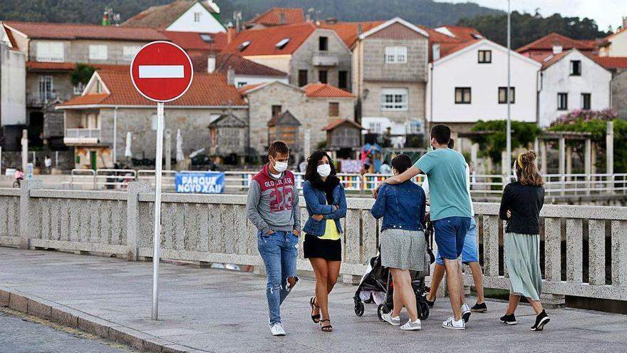 Gente con mascarillas en el paseo marítimo de Combarro.