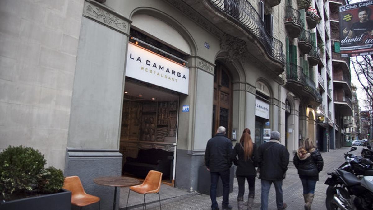 Unas personas pasan por delante del restaurante La Camarga, en la calle Aribau de Barcelona.