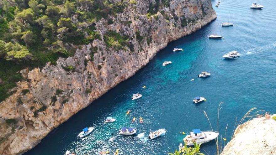 Embarcaciones fondeadas y excursiones de kayaks, en la entrada a la cala de En Caló. | A. P. F.