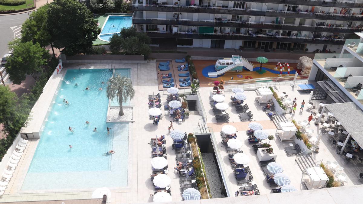 Diversos turistes es banyen a la piscina d&#039;un hotel de Lloret de Mar a l&#039;inici de la temporada turística