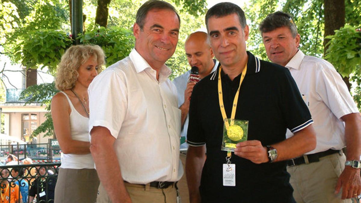 El periodista Sergi López-Egea recibe la medalla commemorativa por sus 20 años en el Tour de Francia de manos de Bernard Hinault.