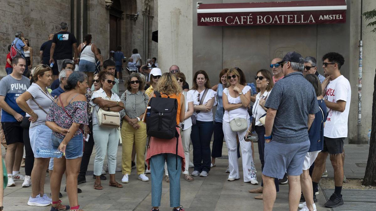 Un grupo de turistas con una guía en la puerta de la Lonja de València